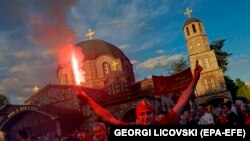 Një mbështetës i partisë kryesore opozitare në Maqedoninë e Veriut, VMRO-DPMNE, mban një pishtar gjatë një tubimi në prag të zgjedhjeve parlamentare dhe balotazhit presidencial, që do të mbahen më 8 maj.