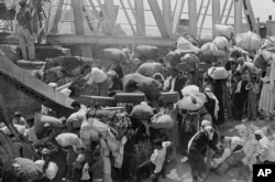 Na ovoj fotografiji od 22. juna 1967. palestinske izbjeglice nose svoje stvari dok se pripremaju prijeći srušeni most Allenby preko rijeke Jordan iz dijela Jordana koji je okupirao Izrael. Mnoge izbjeglice rekle su da su ih Izraelci natjerali da odu.