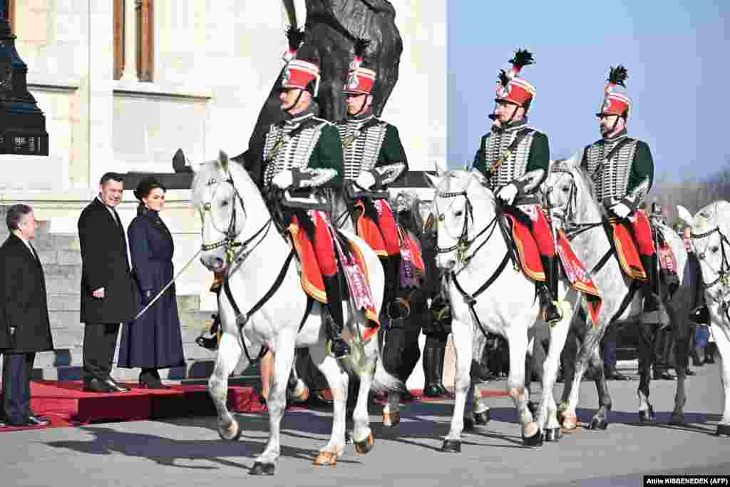 Președinta ungară Katalin Novak (a treia de la stânga) și președintele kârgâz Sadîr Japarov (al doilea din stânga) asistă la parada gărzii de onoare în timpul unei ceremonii de bun venit în fața clădirii parlamentului din Piața Kossuth din Budapesta.