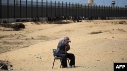 Muškarac sjedi u kampu za raseljene osobe u Rafahu na jugu Pojasa Gaze uz granicu sa Egiptom, 28. aprila 2024., usred tekućeg sukoba između Izraela i palestinske militantne skupine Hamas.