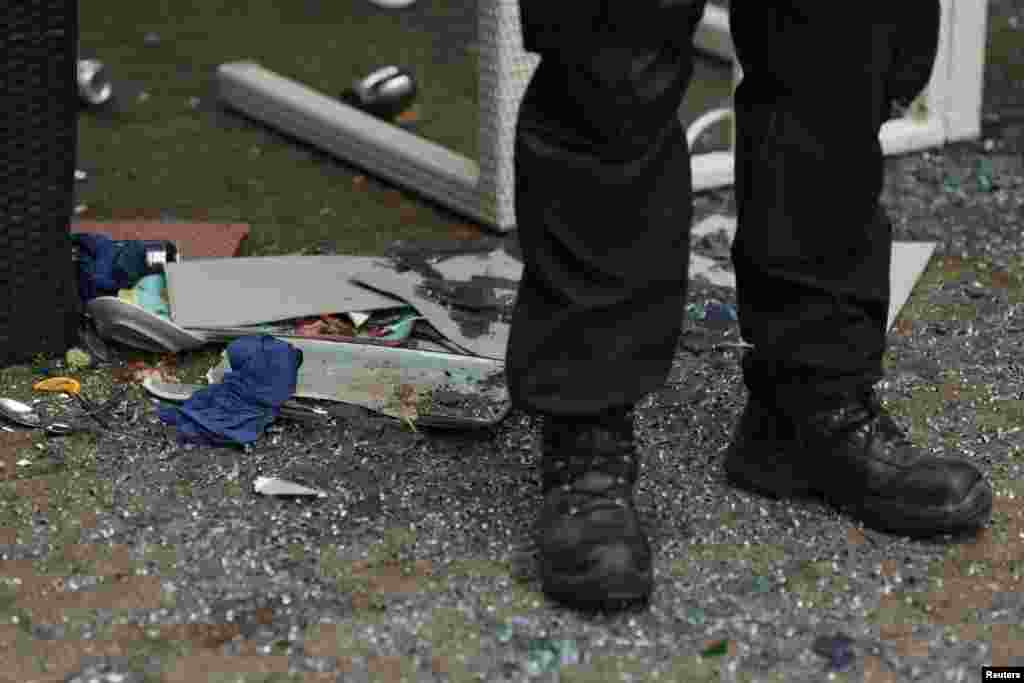 Policajac pored razbijenih stolova restorana nakon sukoba navijača Srbije i Britanije, 16. juni 2024.