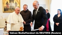 Papa Franja sa ukrajinskim premijeromDenisom Šmihalom koji mu je poklonio keramičkog petla i knjigu fotografija o zverstvima tokom ruske invazije u raznim ukrajinskim gradovima, uključujući Buču, 27. april 2023. 