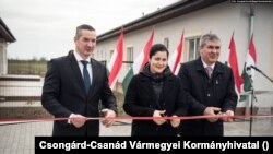 Putnik Lázár (b) 2020 márciusában egy nyolcvan férőhelyes munkásszállót adott át. Az ügyészség szerint a polgármester hetvenmillió forintot utaltatott a saját cégének. Az állami forintokból társasházakat is épített. Most újra megvádolta az ügyészség ennél is súlyosabb ügyekben