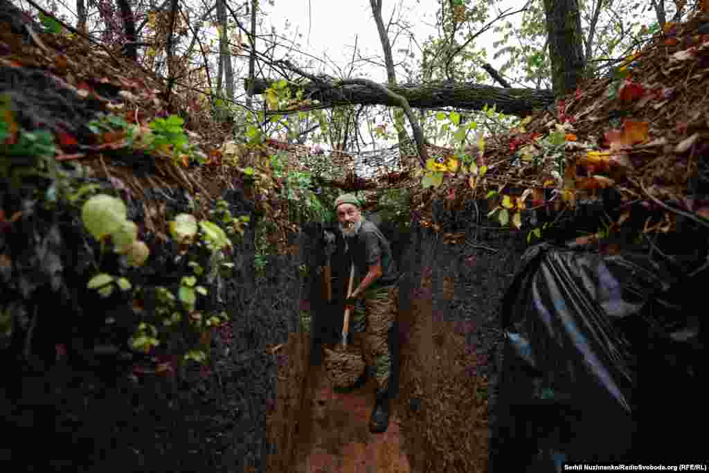 Ukrajinski vojnik lopatom izbacuje blato iz rova koji dijeli s drugim vojnicima. Uprkos tome što su snage Kijeva vratile više od 50 posto teritorije zauzete od početka invazije, ruske trupe još drže 18 posto ukrajinske teritorije.