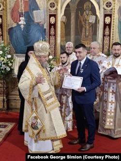 George Simion, liderul AUR, primește Crucea Șaguniană de la Mitropolitul Ardealului.