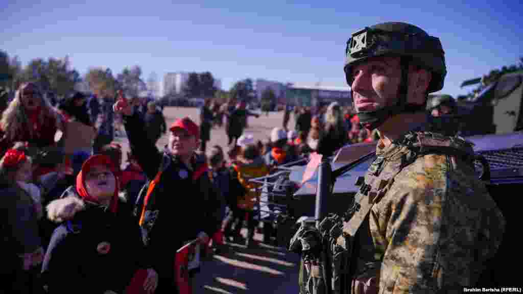 I veshur në uniformë dhe me fytyrë të kamufluar, ky pjesëtar i FSK-së iu përgjigjej pyetjeve të fëmijëve.