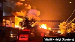 Pompierii lucrează pentru a stinge un incendiu provocat de loviturile rușilor cu drone din regiunea Harkov, de pe 4 mai.
