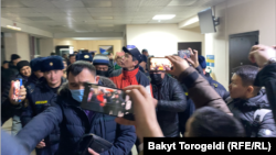 Одного из задержанных журналистов - Сайпидина Султаналиева - ведут в зал судебных заседаний.
