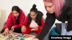 Letiția, Andreea și Andreea aleg cărți în cadrul grupului de sprijin, la sediul Asociației Dream Project