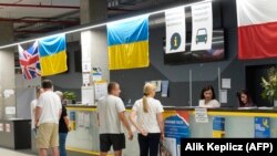 Ukrán menekültek a varsói Global Expo kiállítási csarnokában felállított Humanitárius Segítségnyújtási Központ recepcióján 2022. július 15-én