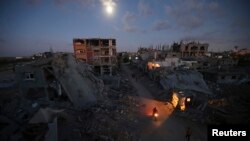 პალესტინელები ნანგრევებს შორის მიდიან. თვითმხილველების თქმით, შენობები ისრაელის შეტევის დროს განადგურდა, ქალაქ ბეიტ ჰანუნში ჩრდილოეთ ღაზის სექტორში. 2014 წლის 7 სექტემბერი.