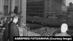 Nicolae Ceaușescu privește mulțimea de la balconul fostului Comitet Central al PCR în timpul unui miting.