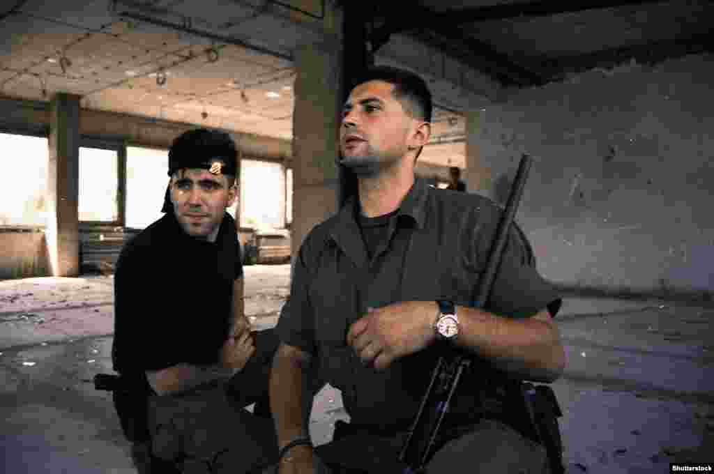 Босненски хърватски бойци в сграда в Мостар през август 1993 г На 8 ноември 1993 г. мостът в Мостар е ударен с около 50 танкови снаряда, а хърватските войници приветстват унищожаването му от позиция на върха на хълма.