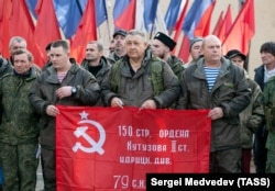 Besorozott orosz katonák és önkéntesek szovjet győzelmi zászlóval az oroszországi Orenburgban 2022 októberében, mielőtt a frontra indulnának