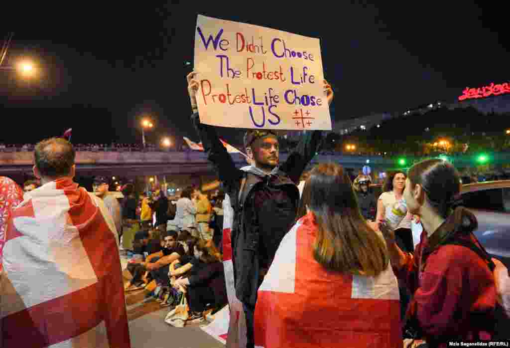 Протестиращ, който се противопоставя на спорния закон за &bdquo;чуждестранните агенти&ldquo;, стои в центъра на Площада на героите в Тбилиси по време на митинг на 2-3 май. Европейският съюз и Съединените щати осъдиха спорния закон, който си проправя път през грузинския парламент след ожесточените сблъсъци между полицията и протестиращите, избухнали късно на 1 май.