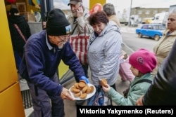 Цучико предлага курабийки на малко момиче от Харков.