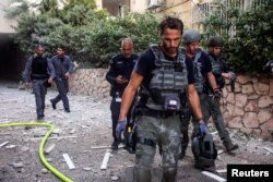 Poliția israeliană și alți oficiali de securitate lucrează în timp ce rachetele sunt lansate din Fâșia Gaza, în Tel Aviv, Israel. 