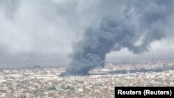 Snimci drona prikazuju ptice u prvom planu dok se oblaci crnog dima nadvijaju iznad Bahrija, poznatog i kao Severni Kartum, Sudan, maj 2023.