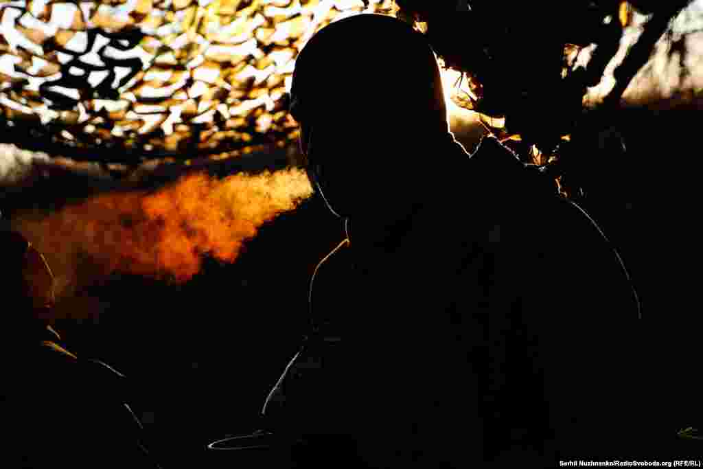 უკრაინული ნაღმმტყორცნელთა ჯგუფის წევრი სიგარეტს ეწევა მზის ამოსვლისას ბახმუტთან მდებარე პოზიციაზე. 2023 წლის დეკემბერი.