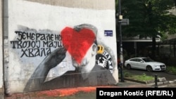 Građani su čeličnim četkama pokušali da uklone mural, ali je akcija završena crtanjem srca koje prekriva Mladićevo lice. (Njegoševa ulica u Beogradu, 8. maja 2023)
