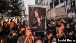 Protest antiguvernamental în Iran. O protestatară ține în mână o fotografie a Mahsei Amini
