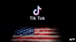 Logo aplikacije društvene mreže TikTok (gore) i zastava SAD-a (dole) prikazana na ekranima dva laptopa u Pekingu.