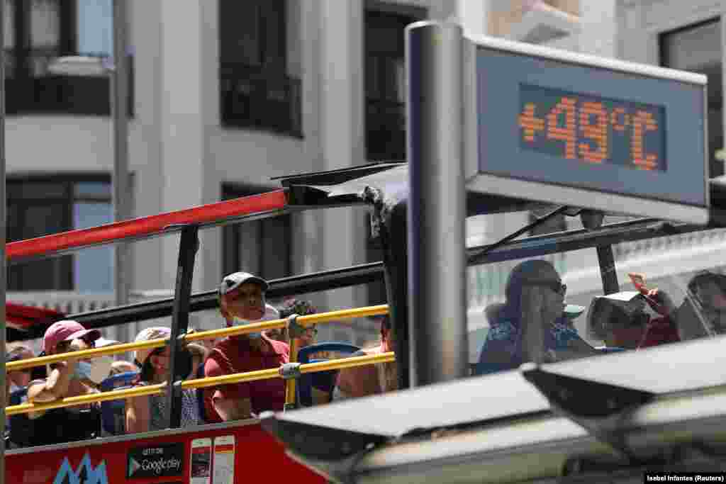 Un autobuz turistic trece pe lângă un termometru care afișează 49 de grade Celsius pe Gran Via, în timpul celui de-al doilea val de căldură al anului, la Madrid, Spania, 15 iulie 2022. În&nbsp;Spania&nbsp;și&nbsp;Portugalia s-au înregistrat în ultimele zile peste 1.000 de decese din cauza căldurii.