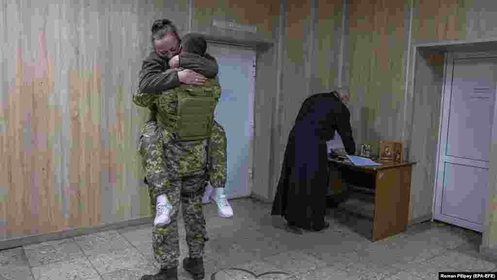 Ifjú házas ukrán katonák ölelkeznek a ceremónia után Kijev mellett. A névtelenséget kérő pár 2015-ben találkozott először Kelet-Ukrajnában, amikor mindketten az Oroszország által támogatott szakadárok ellen harcoltak. Kapcsolatuk azután kezdődött, hogy a 2022-es orosz invázió alatt véletlenül újra találkoztak