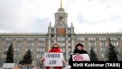 Dy gra mbajnë pankarta me mesazhet “Jo luftë” dhe “Unë nuk zgjedh asnjëherë” gjatë një proteste kundër luftës në qytetin Yekaterinburg në Rusi.