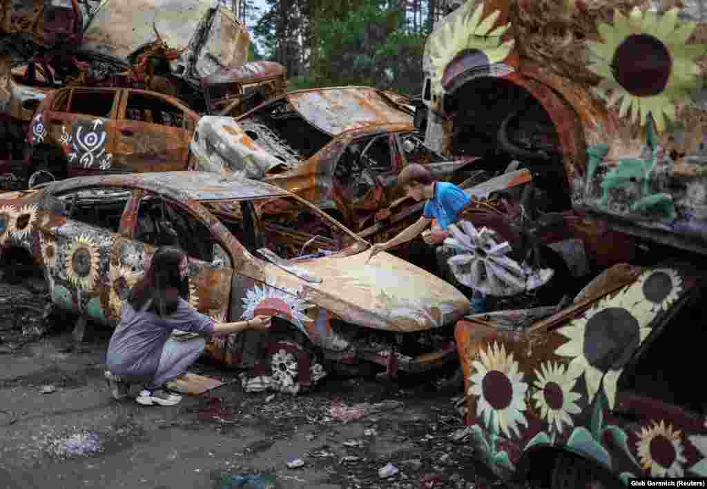 Ukrainian artists Vyacheslav Rybka and Olena Yanko apply paint to one of the many cars that comprise the installation. The U.S. charity beautifyearth.org is accepting tax-deductible donations for the artists, and details will be posted soon on where to buy NFTs. Trek Kelley says other Ukrainian cities have offered sites for more of their art. &ldquo;They want to beautify these distressed areas until they can be rebuilt so...there&rsquo;s some brightness and color and nature springing up out of the ruins, in a type of rebirth.&rdquo;