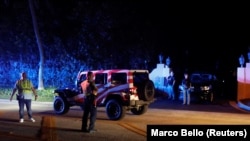 Полицајци и членови на тајната служба чуваат стража пред домот на поранешниот американски претседател Доналд Трамп во Мар-а-Лаго, откако Трамп рече дека агенти на ФБИ извршиле рација, 8 август 2022 година. 