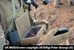 Britanski vojnik gleda u ekran sistema "crni stršljen" dok jednom rukom upravlja dronom.