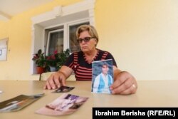 Đulje Gaši u rukama drži fotografiju svoje ćerke Besarte koja je stradala u ratu. Imala je 13 godina kada je ubijena.