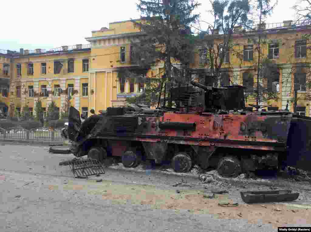 A destroyed Ukrainian armoured personnel carrier is seen in front of a school which, according to local residents, was on fire after Russian shelling, on February 28.