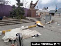 Sub prelatele albe se află cadavrele unor civili uciși de forțele ruse, în timp ce fugeau de teama bombelor din micul oraș, Irpin, din nord-vestul Kievului. Cel puțin opt civili au fost împușcați duminică, 6 martie 2022.