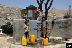 Egy férfi és gyermekei vizet vesznek egy kabuli kútról. (archív fotó)