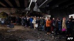 Жители на Ирпин се евакуират към Киев, минавайки под разрушен мост, 7 март 2022 г.