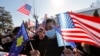 KOSOVO -- Kosovo Albanians wave U.S. and Kosovar national flags in the village of Bibaj, January 20, 2021