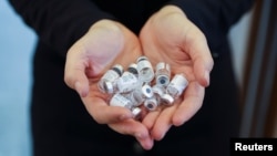 Një person mban në duar doza të vaksinës kundër koronavirusit. 