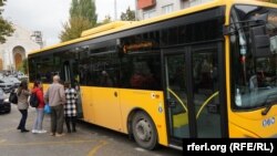 Një autobus i trafikut urban duke u ngarkuar me udhëtarë.