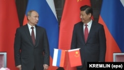 Președintele rus Vladimir Putin (stânga) și omologul său chinez, Xi Jinping, participă la o ceremonie la Shanghai înainte de semnarea unor acorduri privind proiecte de gaz și infrastructură în 2014.