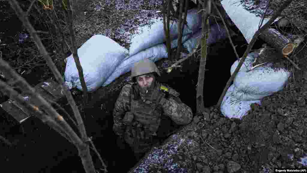 Un militar ucrainean fumează o țigară în tranșeea sa de lângă Bahmut. Situat la întretăierea a două importante căi de acces, orașul Bahmut a fost golit de toți cei 70.000 de locuitori ai săi, iar clădirile și casele din oraș au fost făcute aproape toate una cu pământul.