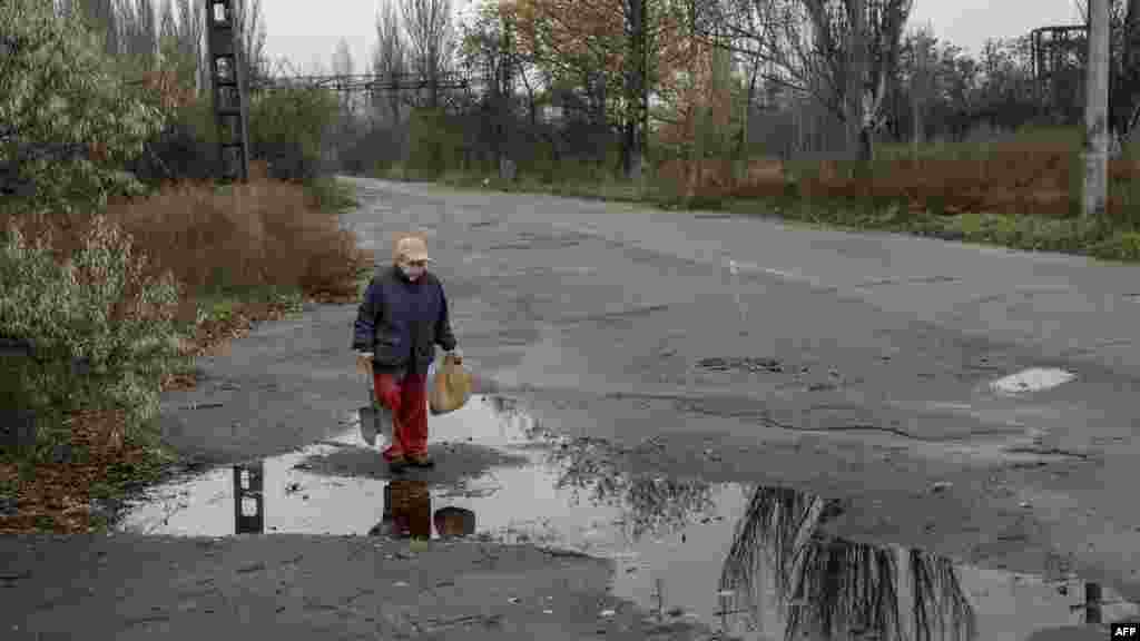 Ez a másik idős asszony szintén vizes ballont cipel.