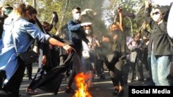 Protestatare din Iran își aruncă în foc voalurile.