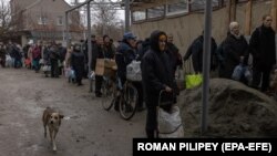 Луѓе чекаат ред за да наполнат шишиња со вода за пиење од бунар во Херсон, 24 ноември 2022 година