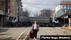 Жена минава край блокада в северната част на етнически разделения град Митровица, Косово, 27 декември 2022 г.