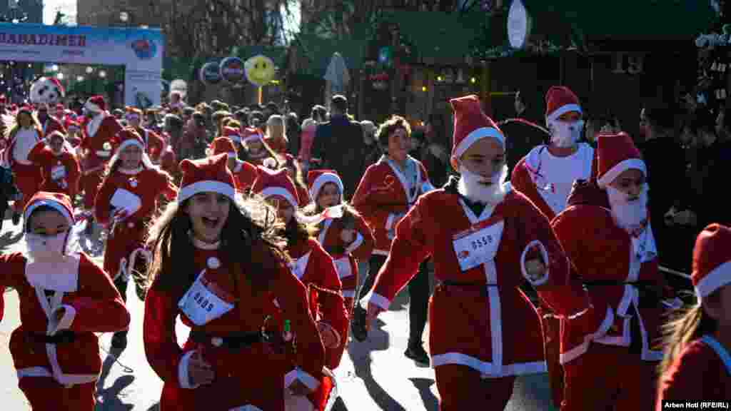 Djeca u odjeći Djeda Mraza trče na mini-maratonu &quot;Trka Djeca Mrazova&quot; u Prištini.
