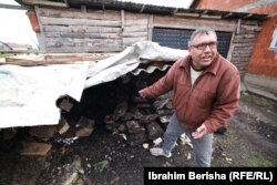 Naser Abazi duke marrë qymyr në oborrin e tij.