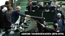 Iranski predsjednik Ebrahim Raisi (desno) predaje budžetske papire predsjedniku iranskog parlamenta Mohammadu Bagheru Ghalibafu tokom sjednice parlamenta u Teheranu 11. januara.