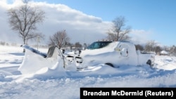 O camionetă cu plug de zăpadă atașat abandonată după furtuna de zăpadă care a lovit regiunea Buffalo, Strada Principală din Amherst, New York, Statele Unite, 25 decembrie 2022. 